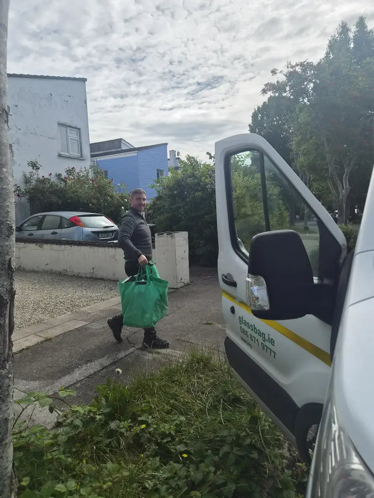 GlassBag driver carrying a full bag of bottles from a North Wicklow doorstep to the collection van.