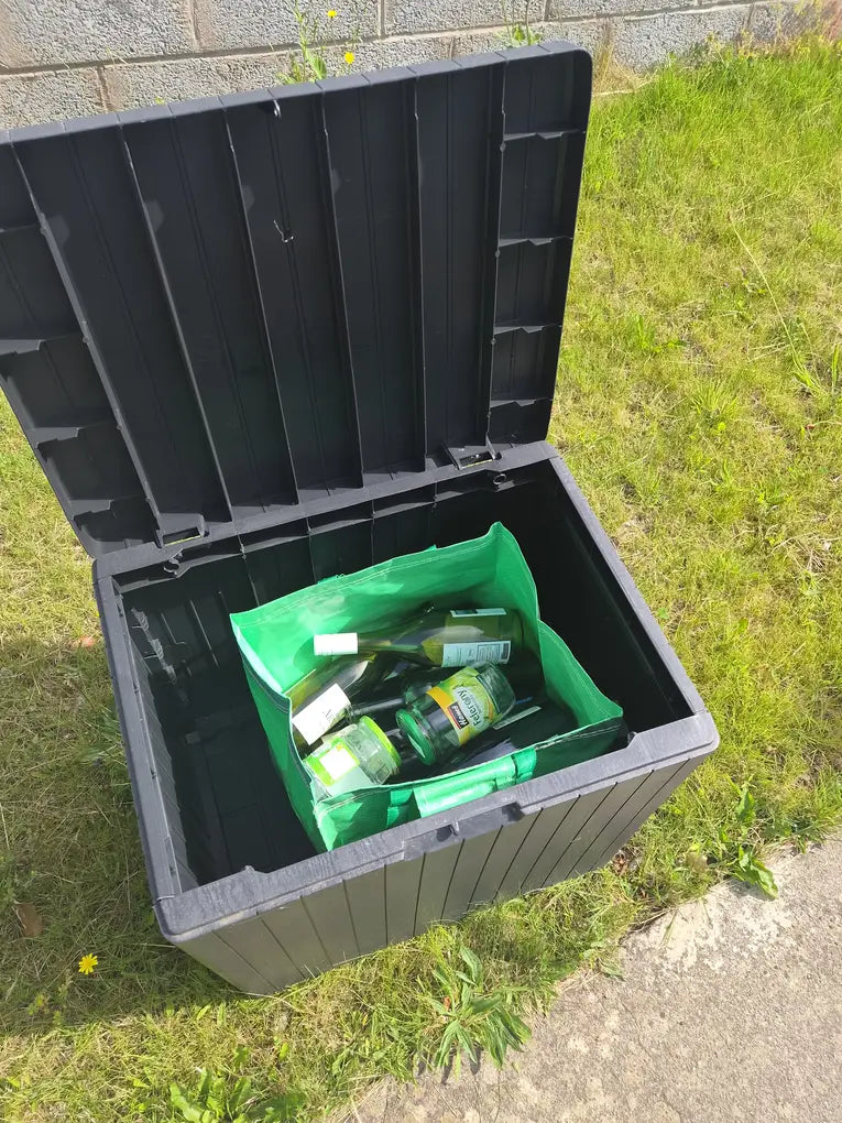 Bottles and jars being transferred carefully from a storage box into a GlassBag collection bag.