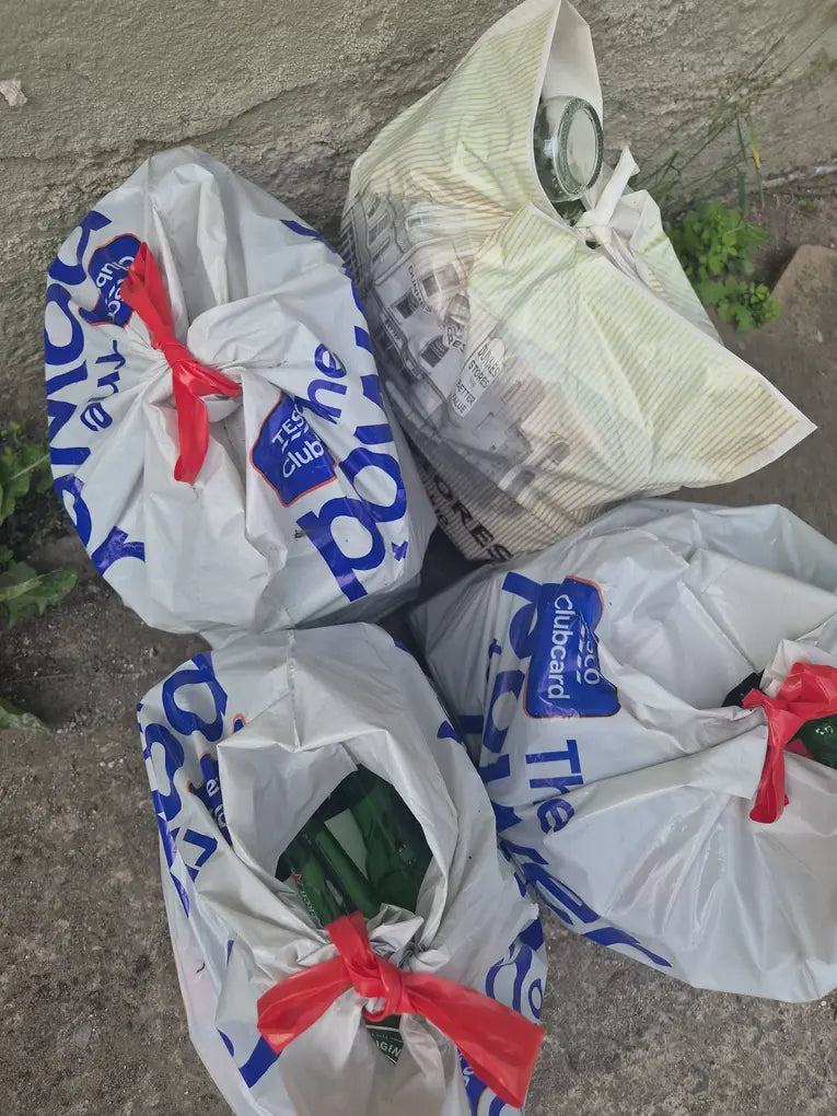 Supermarket bags stuffed with glass bottles piling up before a bottle bank run